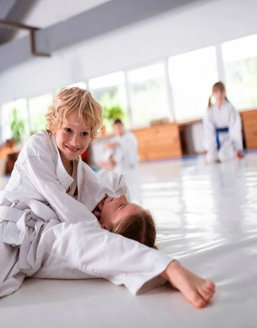 Crianças de kimono praticando jiu-jitsu, em fotografia do material do Método Winners